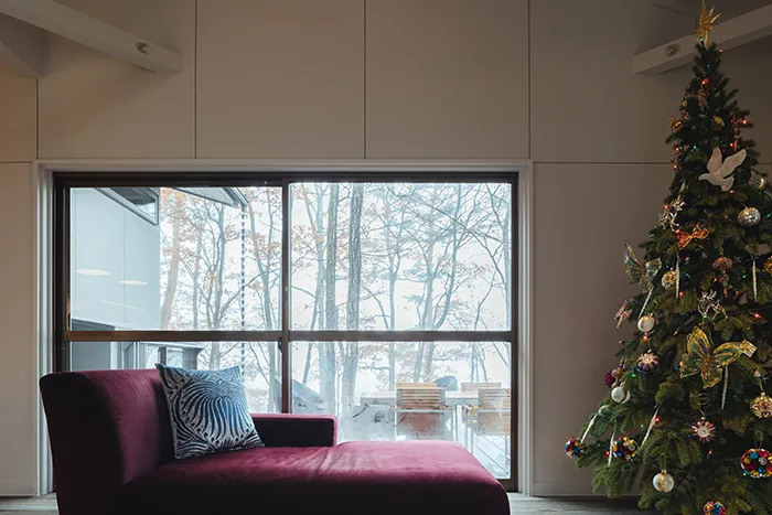 クリスマスツリーを飾った部屋、窓からは小淵沢の自然が見える。