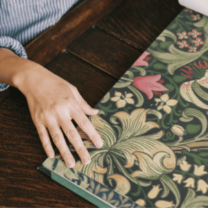 ウィリアムモリスの見本帳に手を添えている