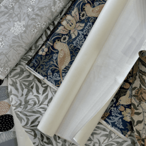 さまざまな柄の国産壁紙サンプルと、裏面のフリース素材が見える壁紙ロールのイメージ。