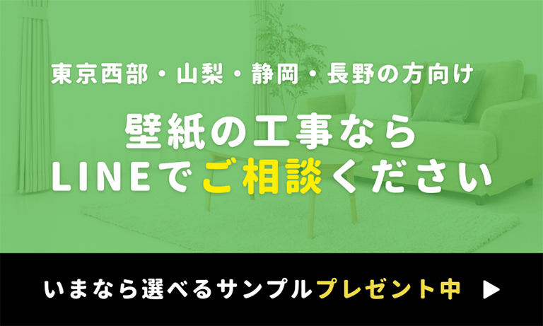 東京西部・山梨・静岡・長野エリア向けに壁紙工事の相談をLINEで受け付けていることを案内するバナー。「壁紙の工事ならLINEでご相談ください」と大きく書かれ、下部には「いまなら選べるサンプルプレゼント中」と強調された告知あり。背景にはグリーンのフィルターがかかったリビングの写真。