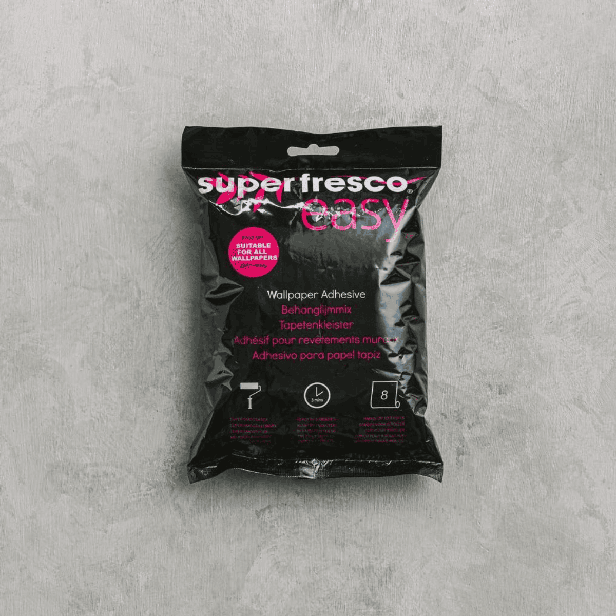 黒いパッケージにピンクのロゴが入った「Superfresco Easy」壁紙用接着剤のパッケージ。中央に&ldquo;Wallpaper Adhesive&rdquo;と表記され、ローラー・乾燥時間・使用量のアイコンが並ぶ製品イメージ。