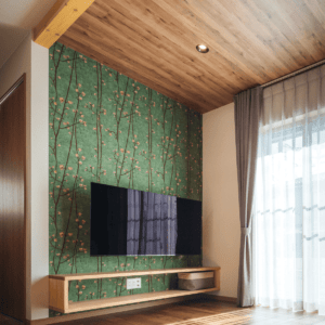 梅の花が咲く枝を描いた壁紙をアクセントにしたリビングのインテリアイメージ。