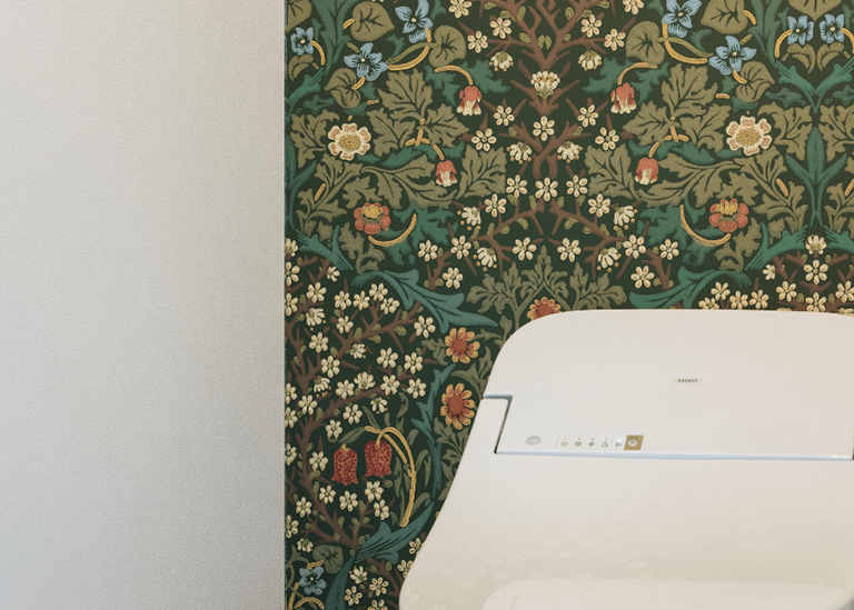 トイレの壁紙にウィリアム・モリス柄を使用した事例。左は白い無地壁紙、右は緑の植物柄壁紙でアクセントをつけた比較。