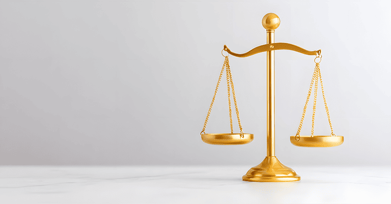 白い背景の上に置かれた金色の天秤。左右に吊り下げられた皿が均等にバランスを保ち、シンプルでミニマルな構図が公平性や比較を象徴している。