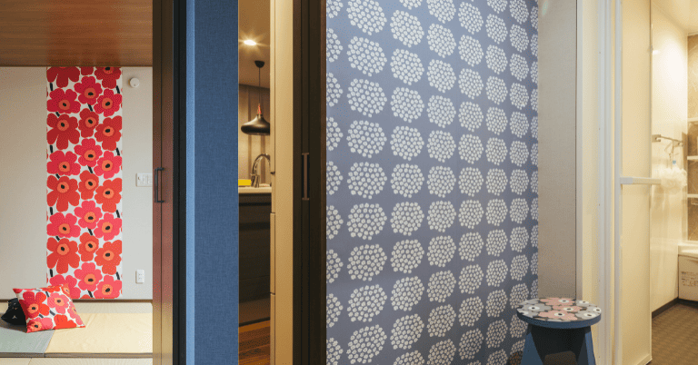 室内の壁に大胆な赤い花柄やグレー地に白い花柄の壁紙を貼ったインテリア例。和室や廊下の空間でアクセントとして使用されている様子