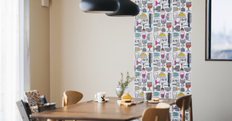 マリメッコのKippis（キッピス）柄の壁紙をアクセントに使ったダイニング空間。グラスモチーフのカラフルなデザインがテーブル横の壁一面に貼られている